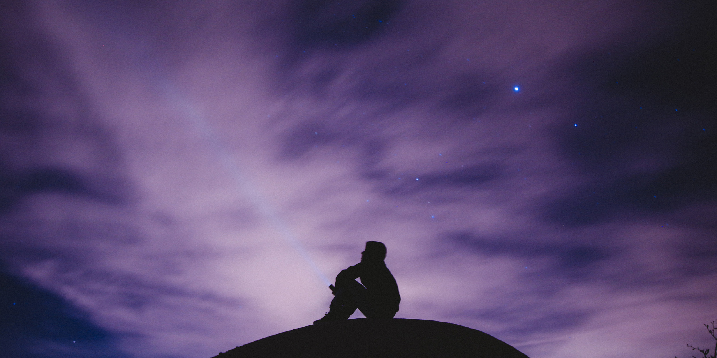 Image of man seated under stars