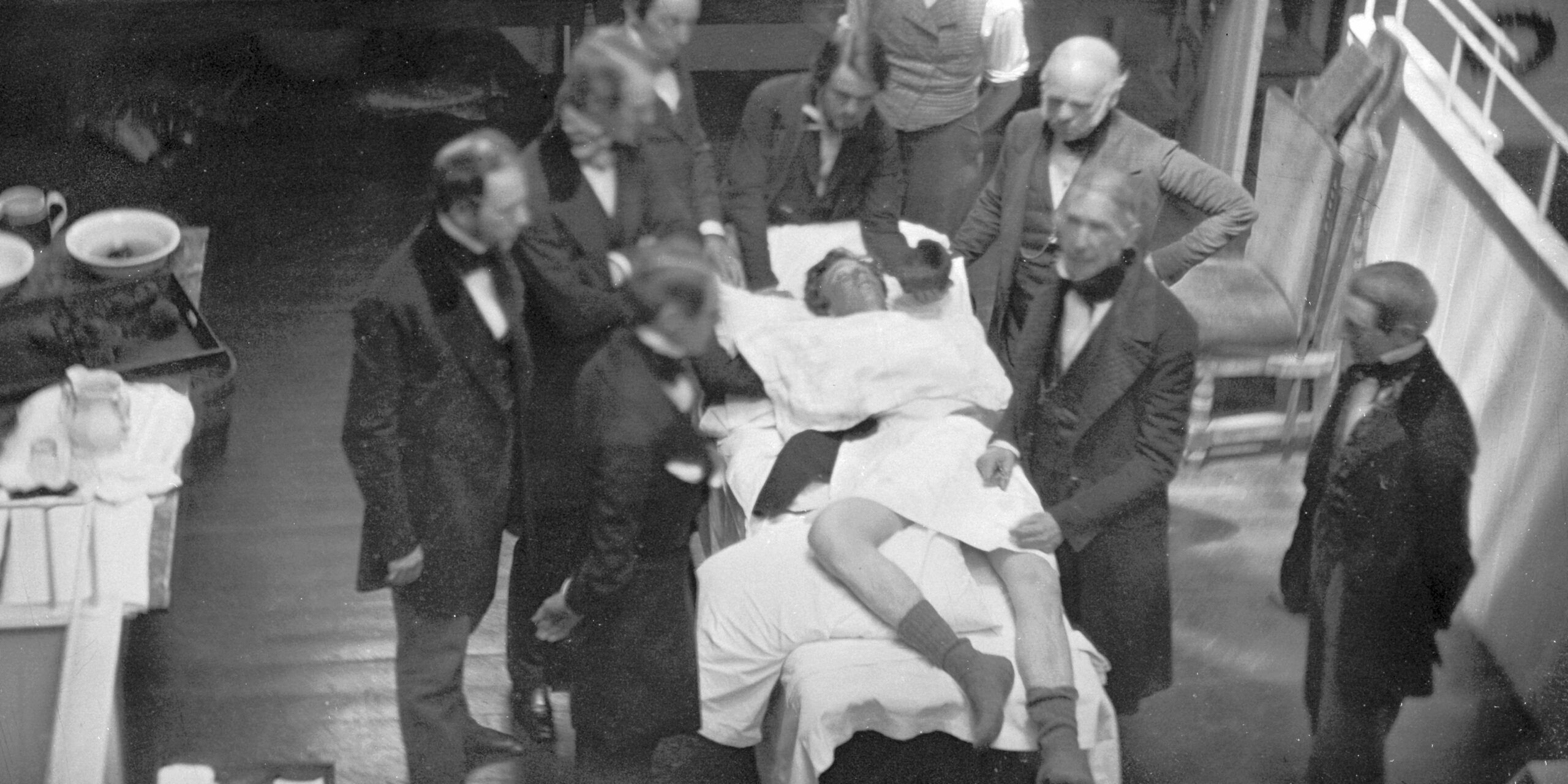 Image of doctors crowded around patient in old operating theater