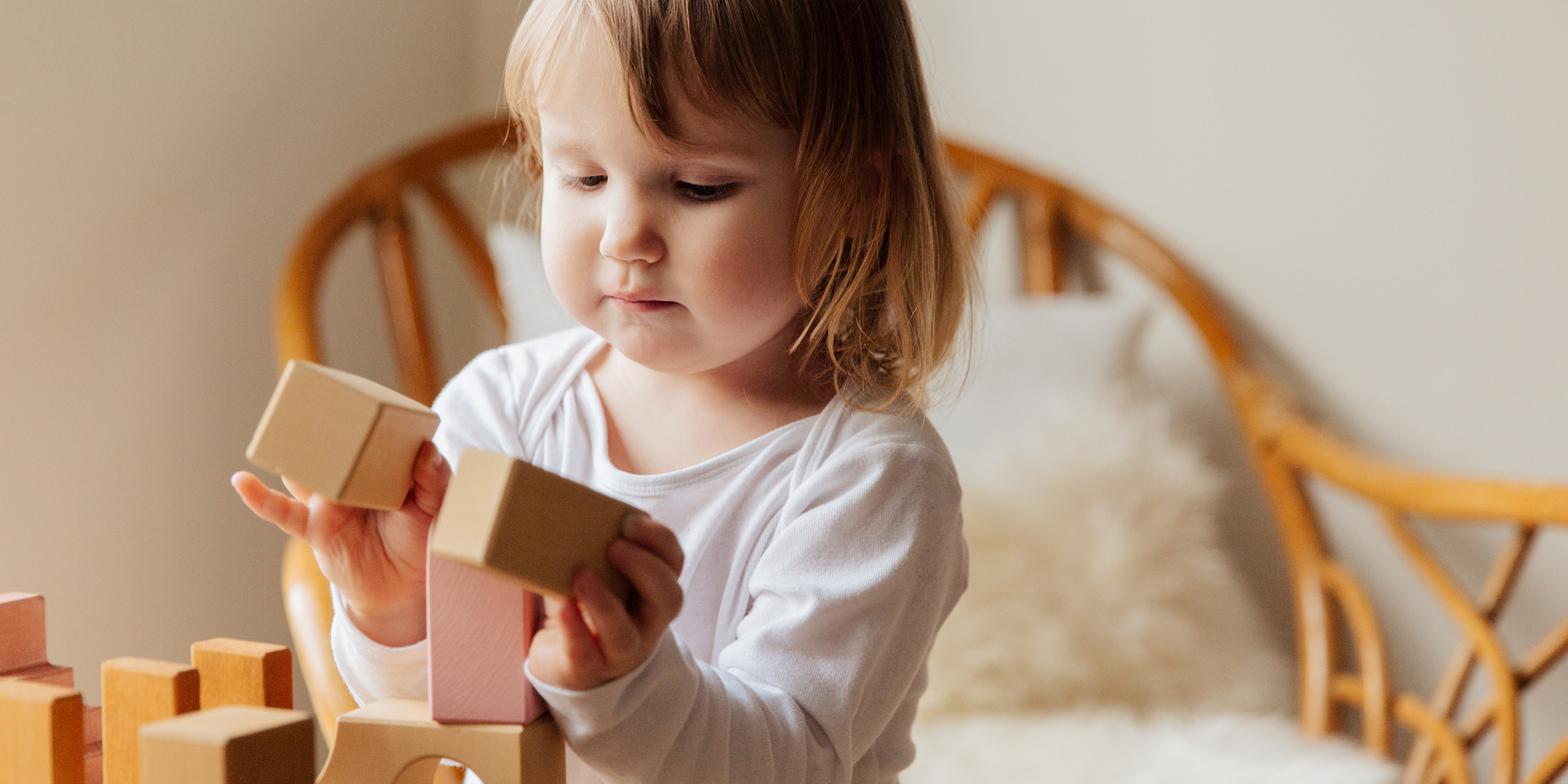 Image of a toddler playing with wooden blocks