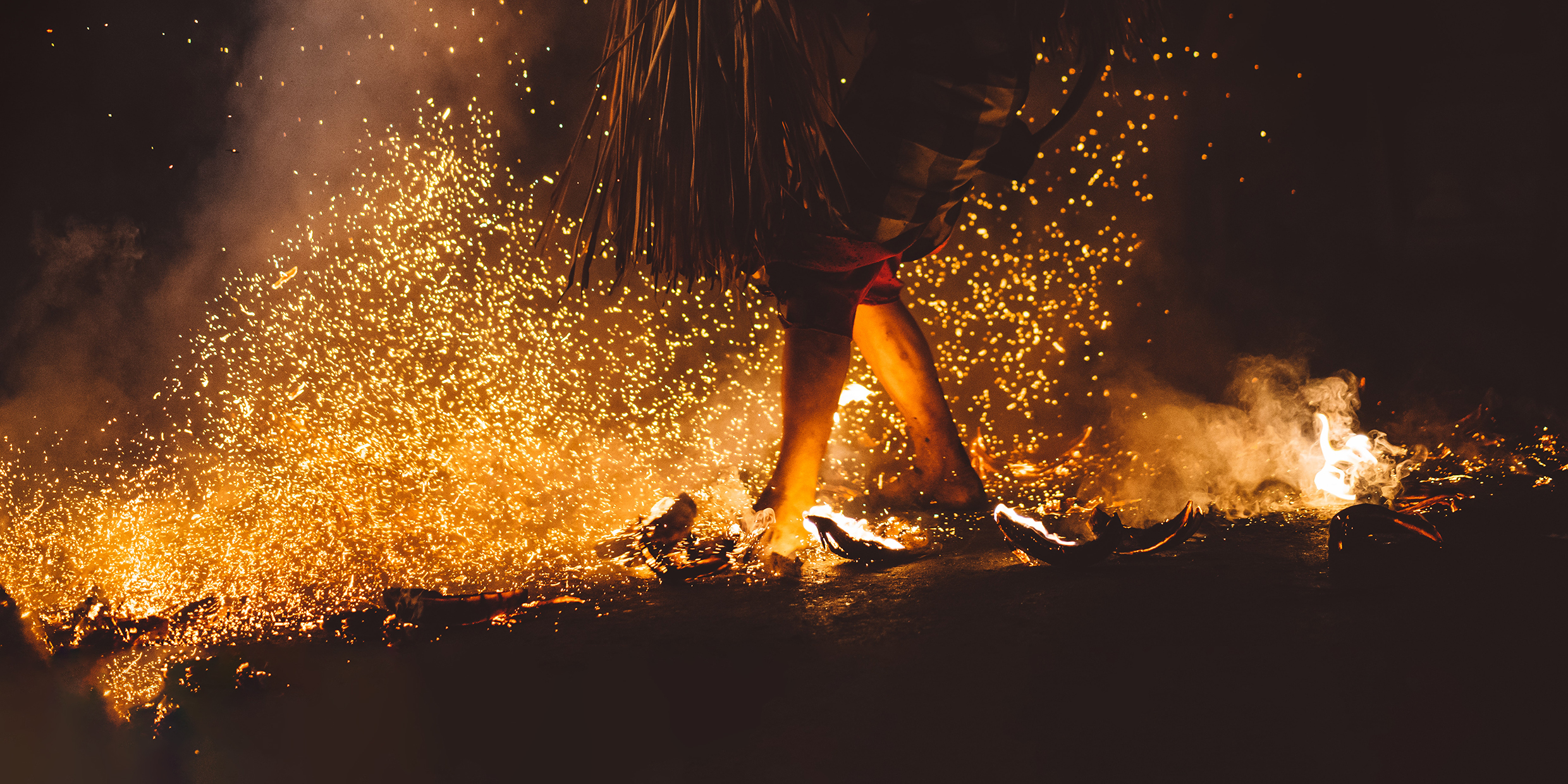 Image of person walking barefoot across hot coals