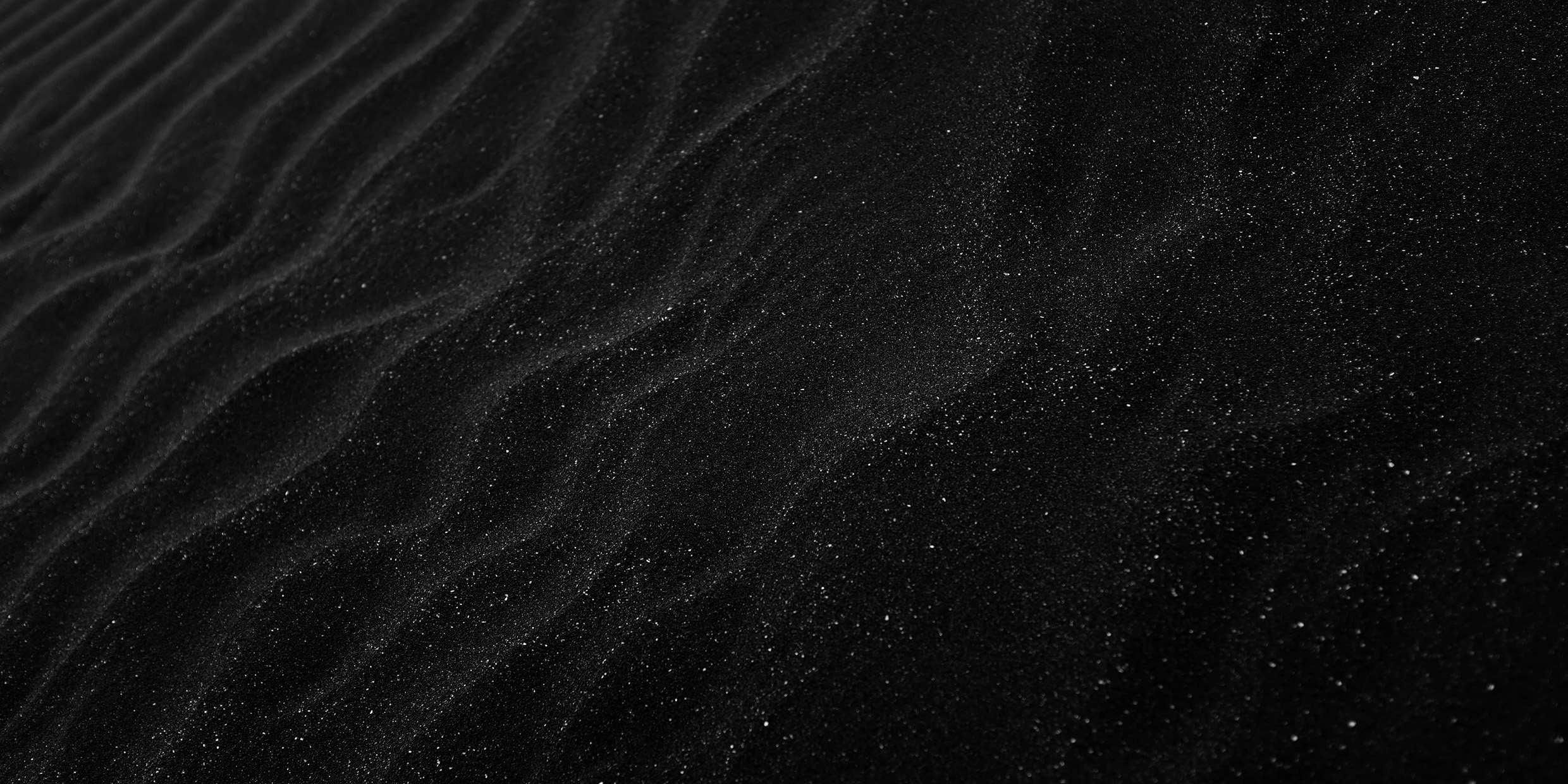 Artistic image of dark rippled sand and pinpoints of light