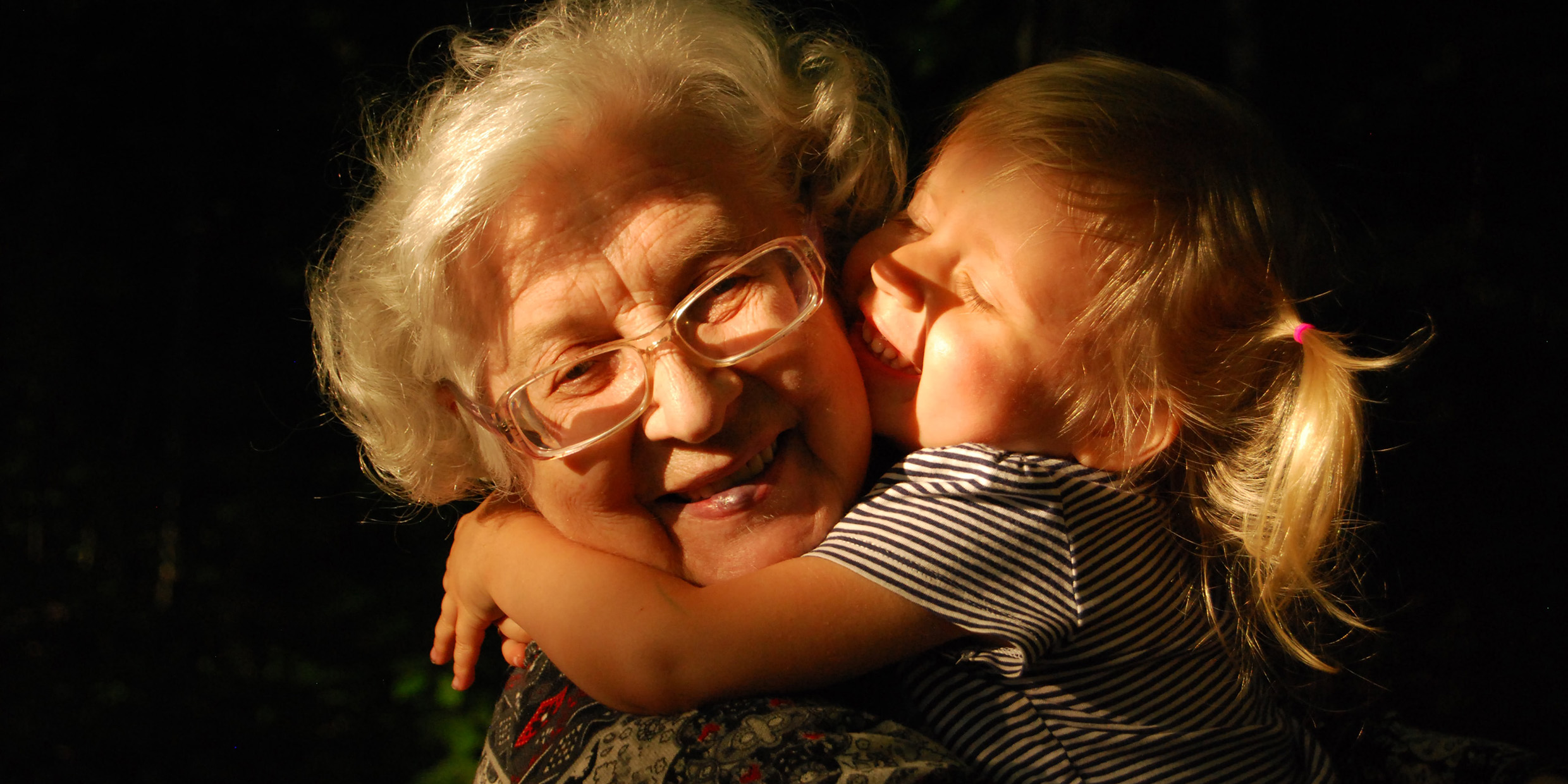 Image of a child hugging an elderly woman