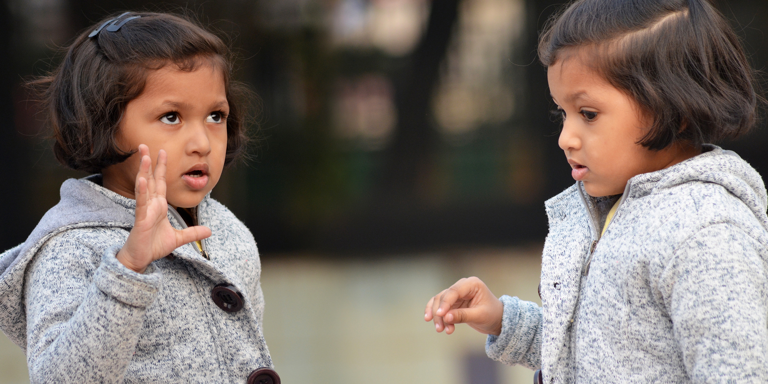 Image of young twin girls talking