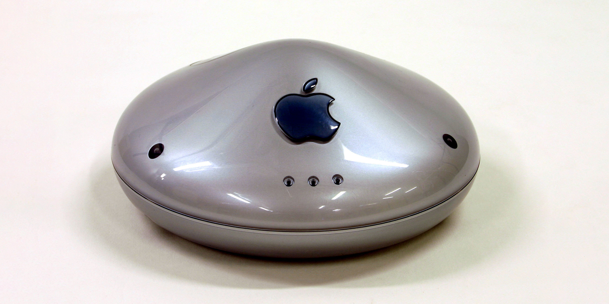 Image of a round wireless router with a large Apple logo
