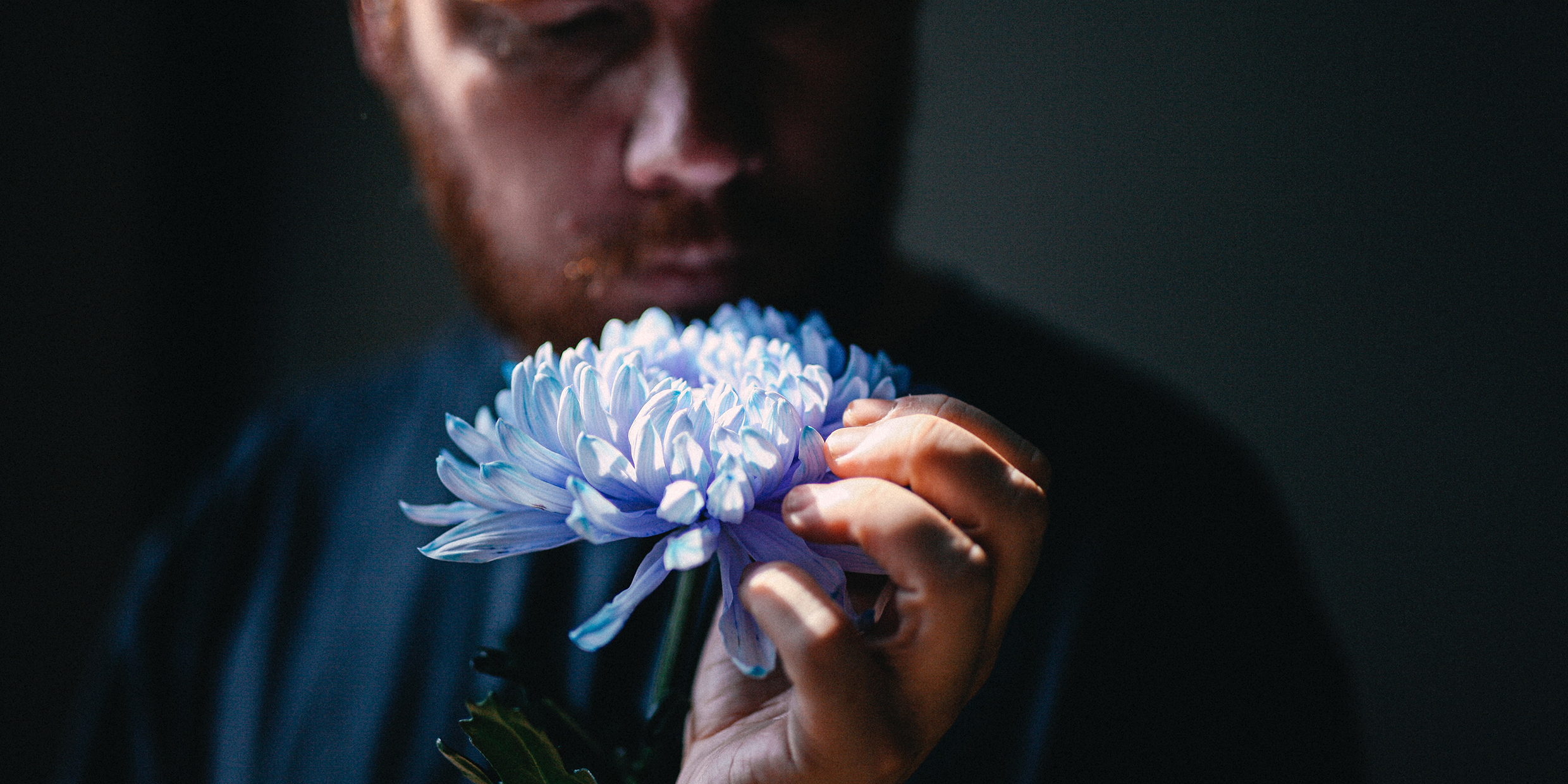 Image of a man smelling a flower