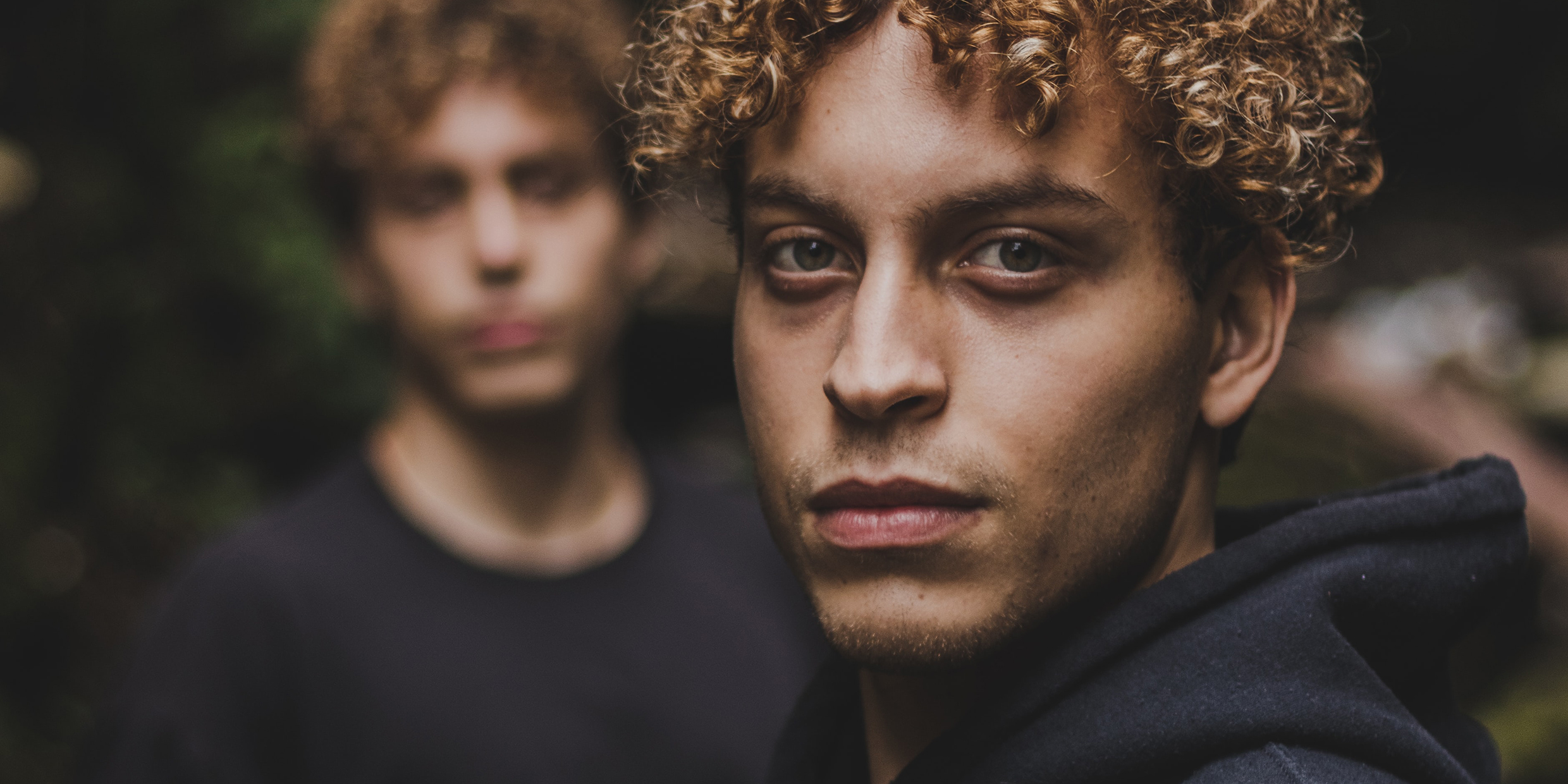 Image of two male twins with one in sharp focus and the other blurred