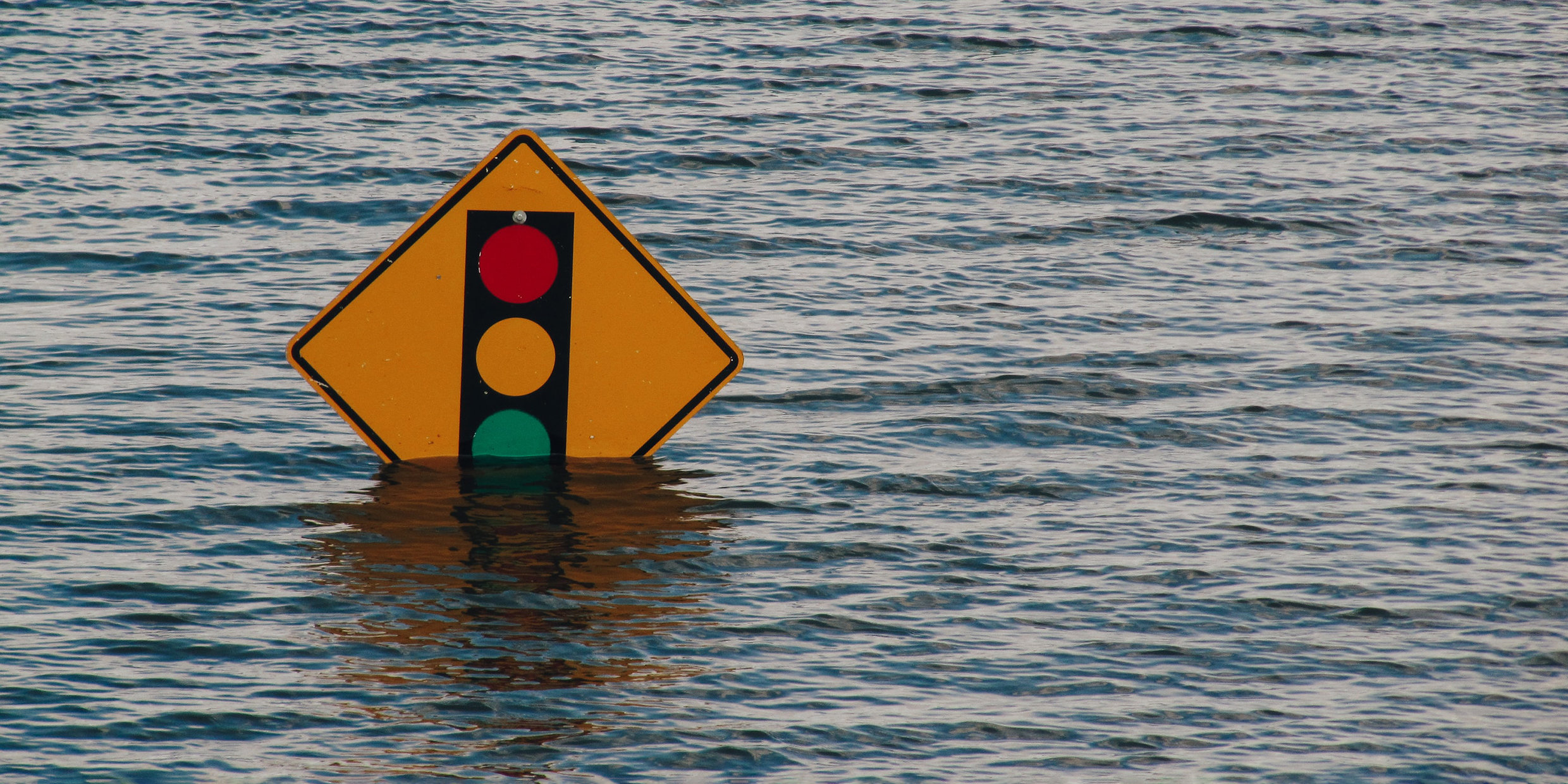 Image of a traffic sign partially submerged in floodwater