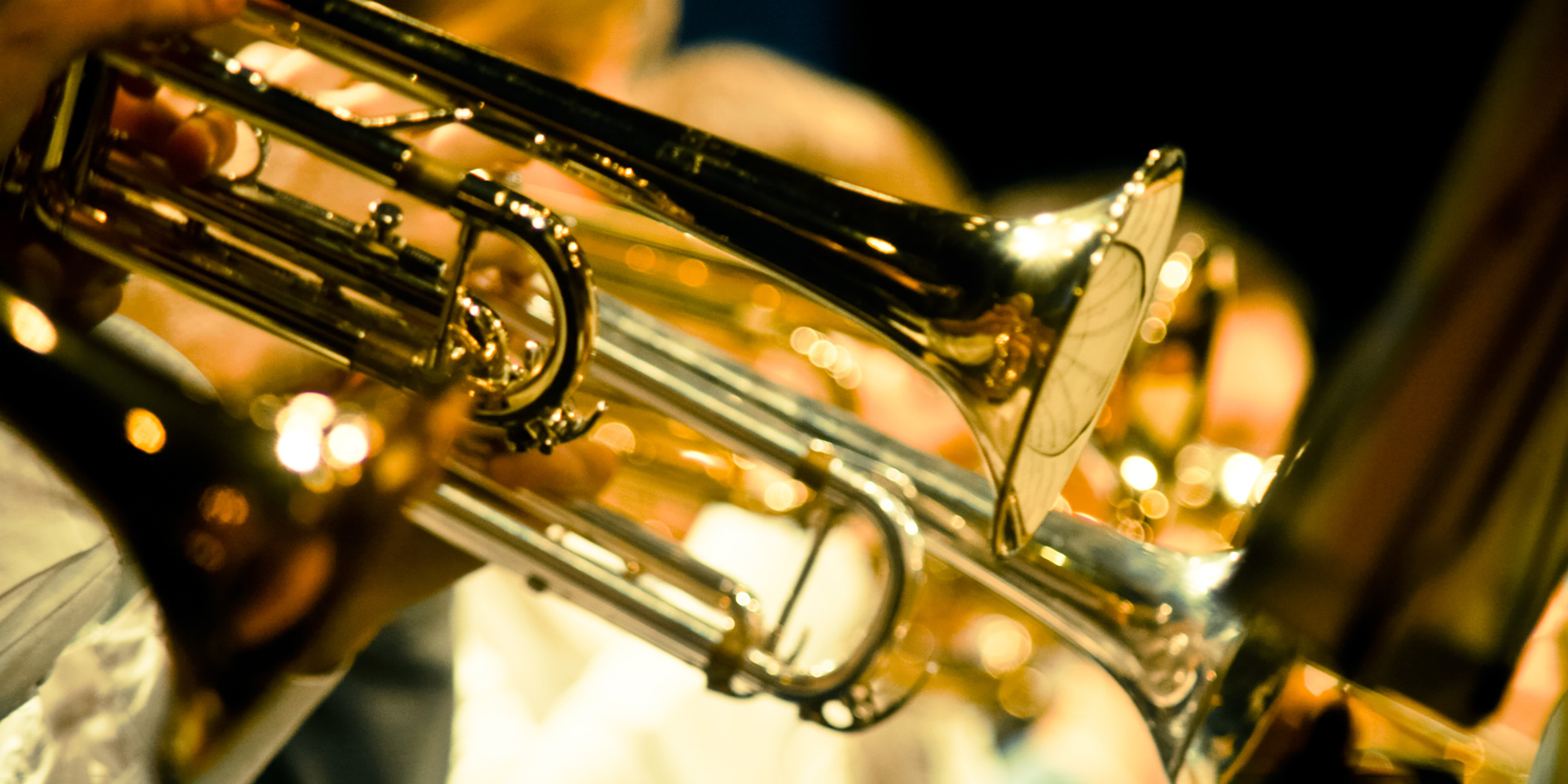 Image of shiny brass instruments playing in an orchestra