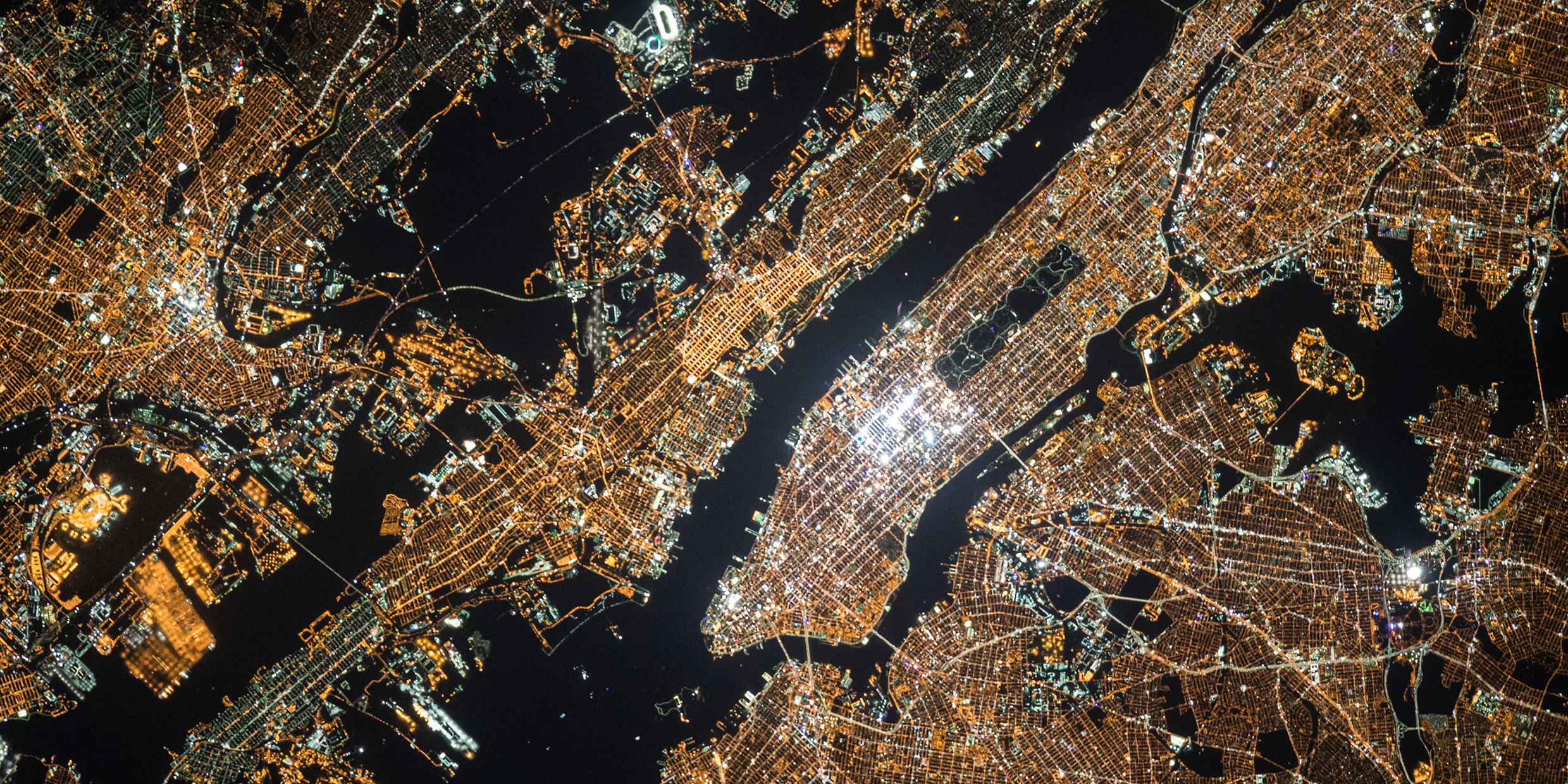 Aerial image of the glowing lights of New York City at night