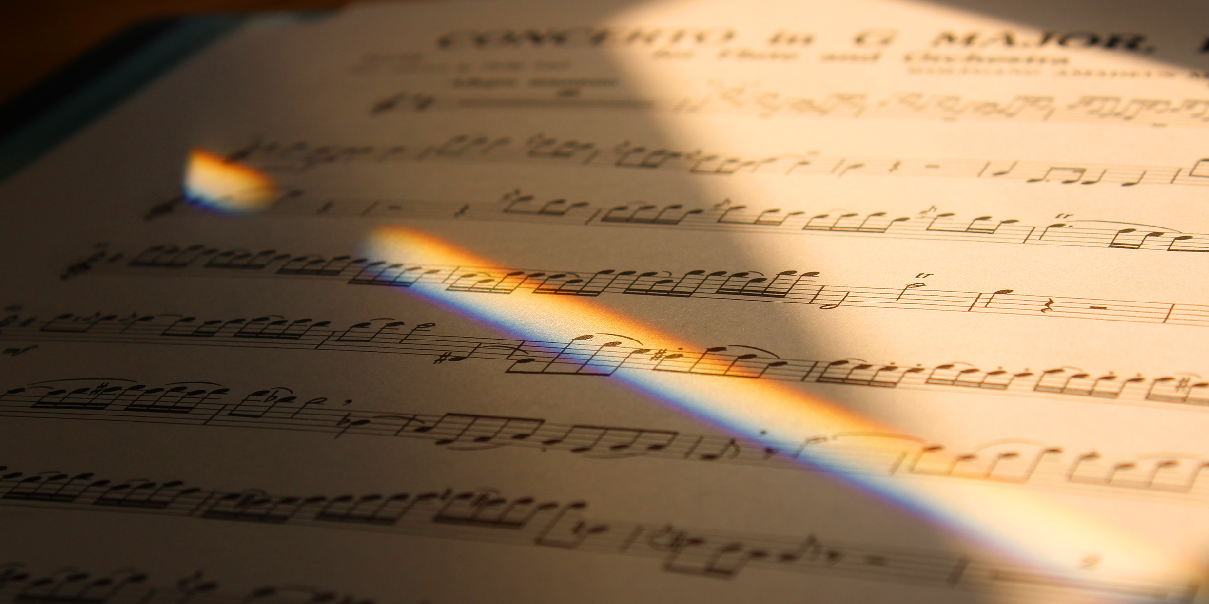 Image of a spectrum of color illuminating a page of sheet music
