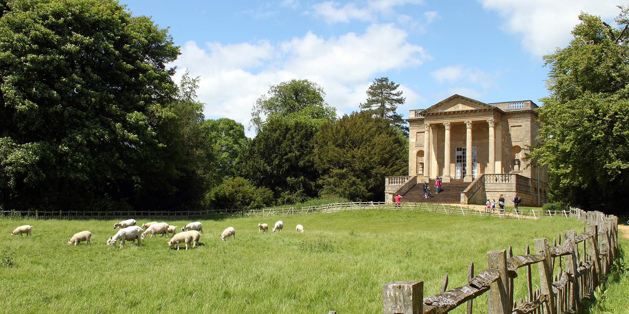 Image of a English landscape garden with a open pasture and a classical-style building