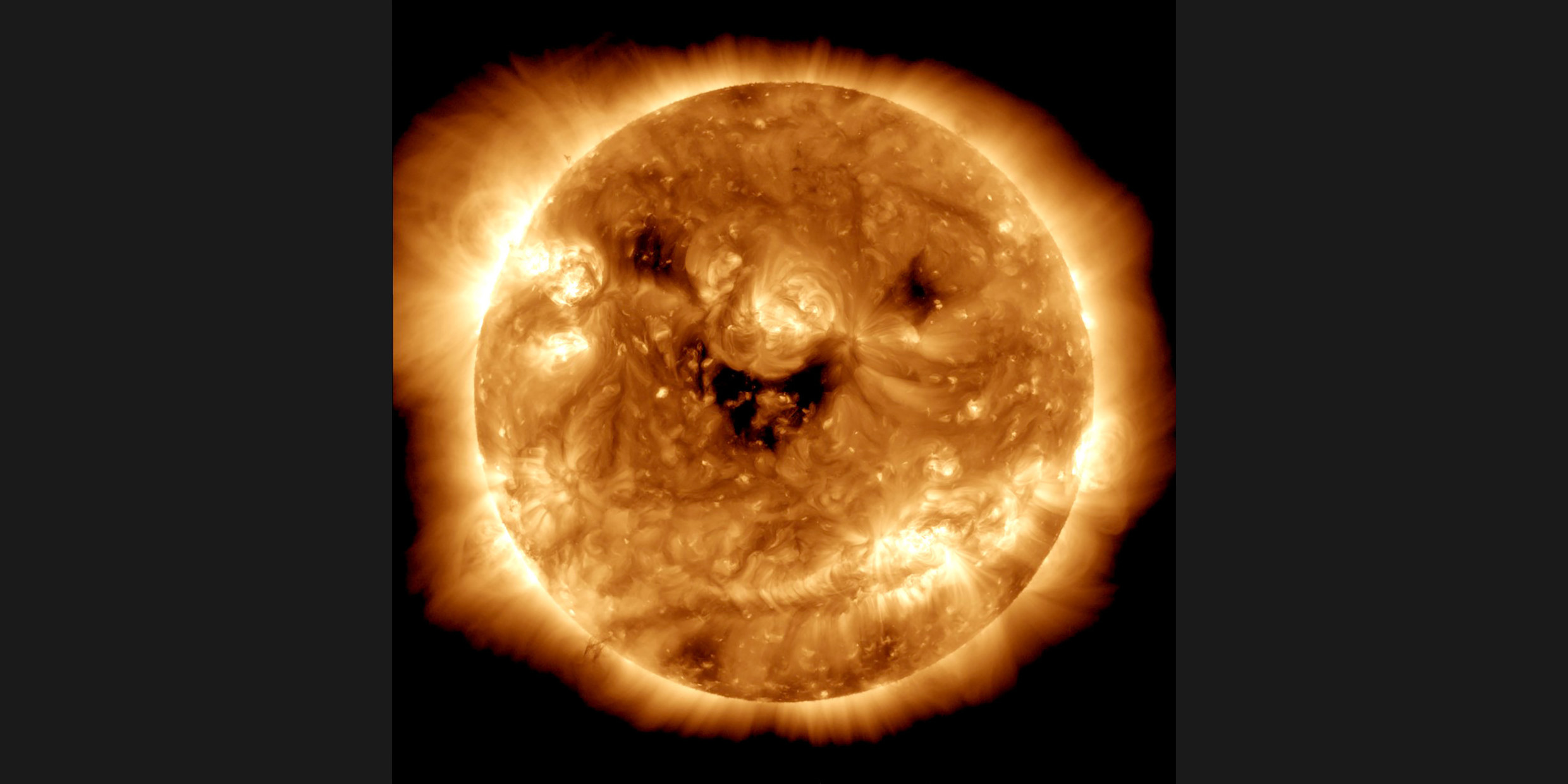 Telescopic image of the sun with dark spots that resembles a smiling face