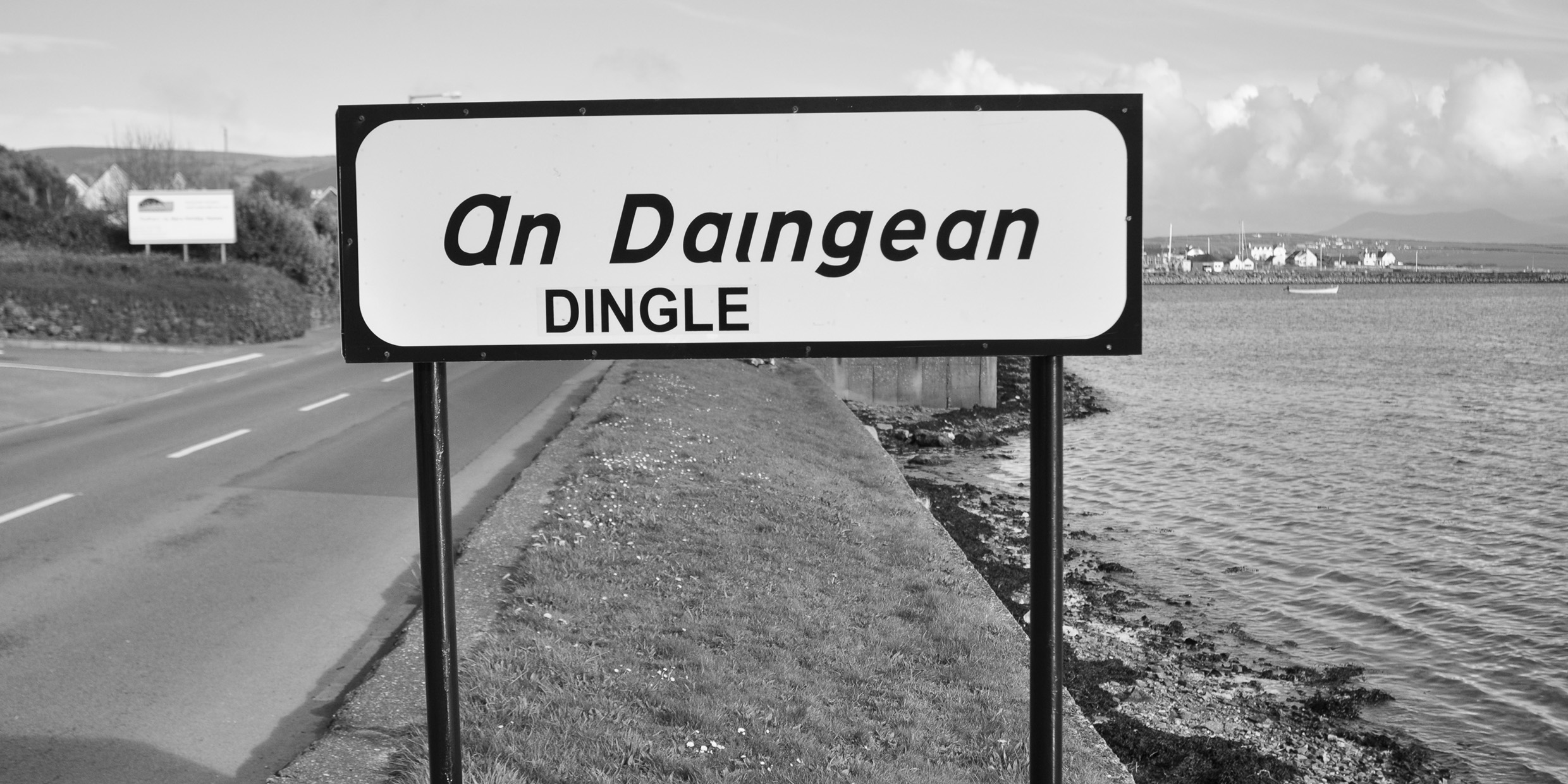 Image of a road sign in Ireland with a placename in both Irish and English