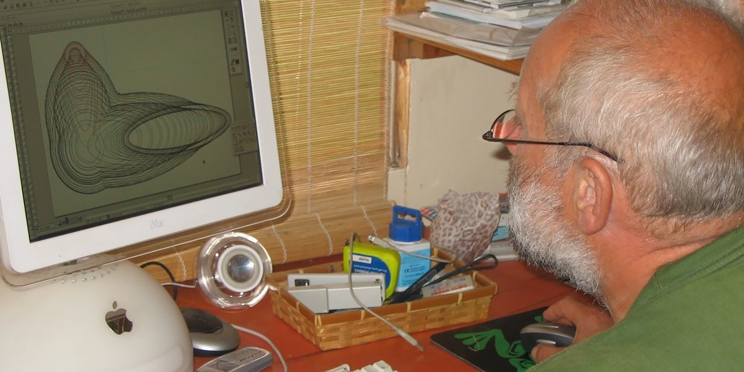 Image of the artist John Holstead designing a sculpture on his computer