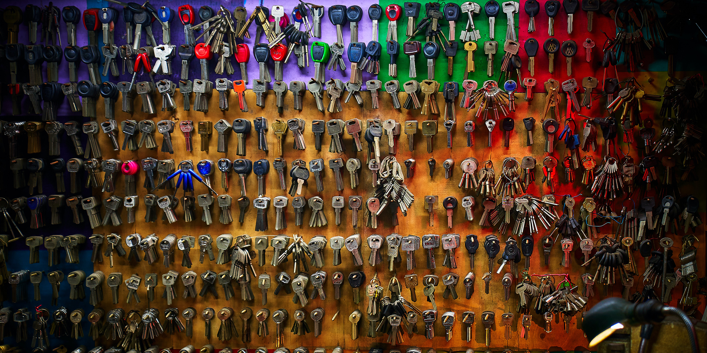 Image of a large assortment of keys hanging from a peg board