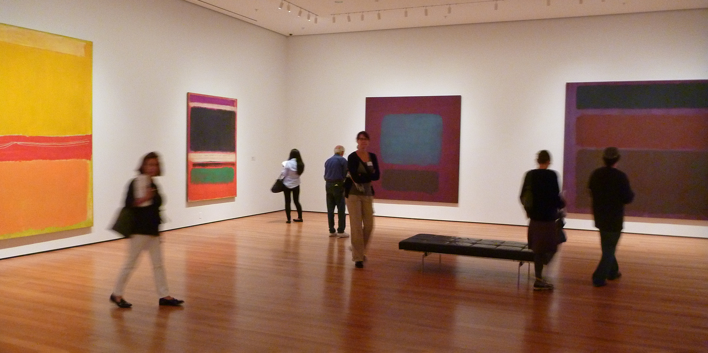 Image of a museum gallery displaying abstract paintings