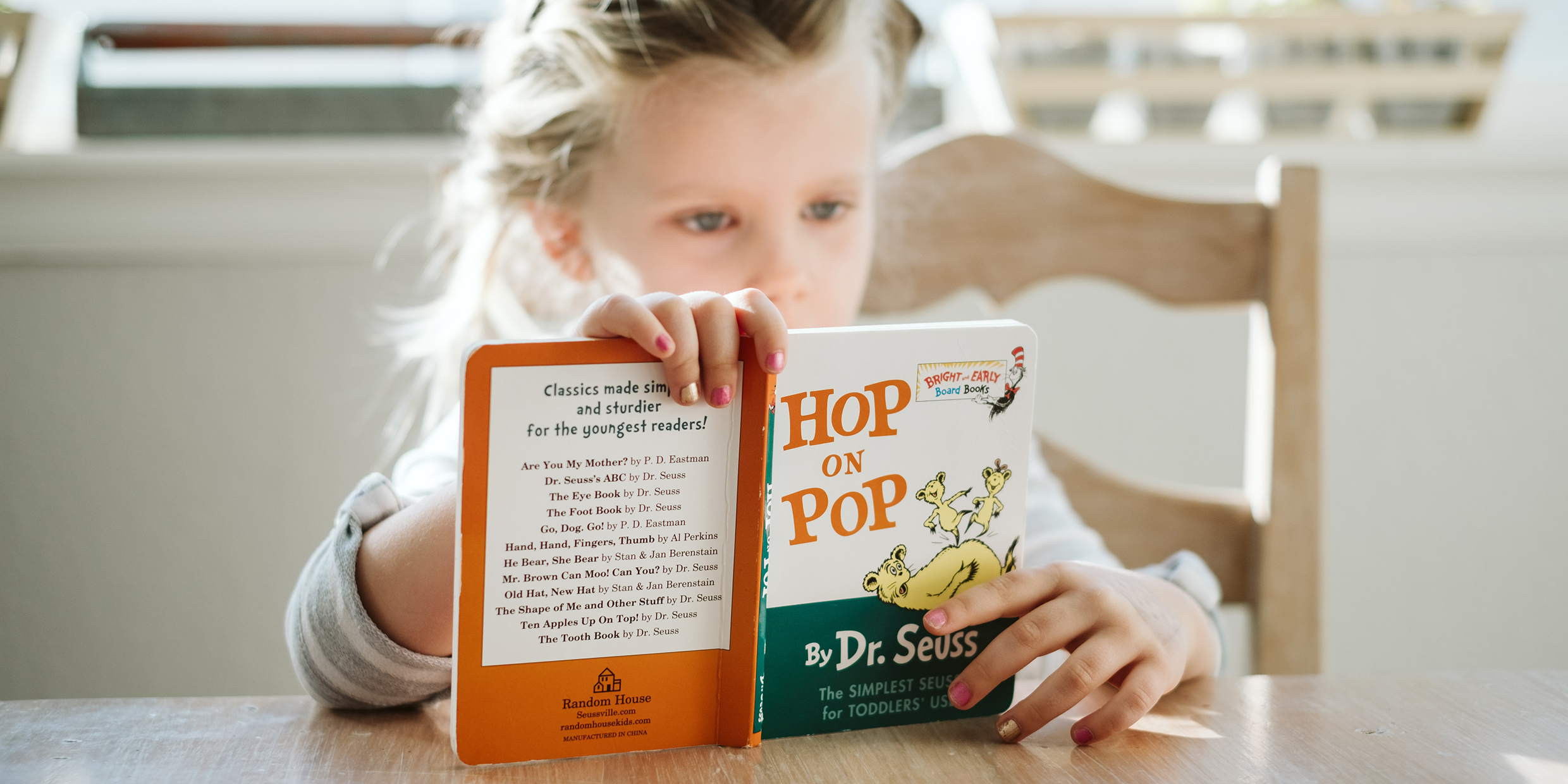 Image of a child reading a book by Dr. Seuss