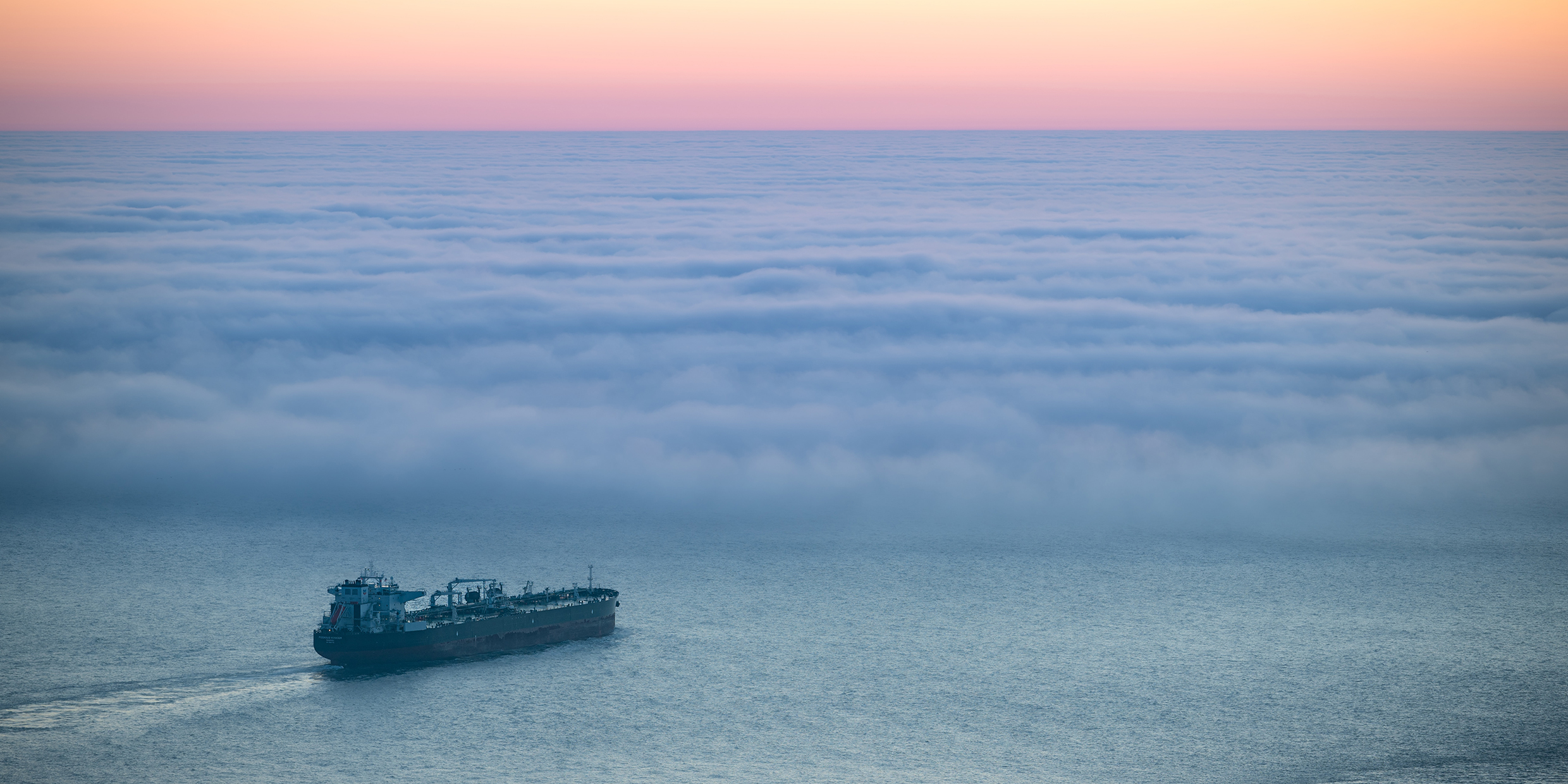 Image of a tanker ship sailing towards a fog bank